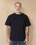 Man wearing a black Mock Neck t-shirt against a wood background. Model is 5'11", 198lbs wearing size L