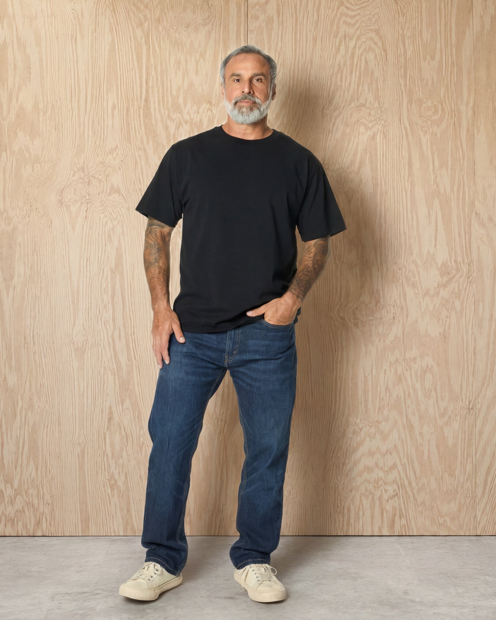 Man wearing a black Mock Neck t-shirt against a wood background. Model is 5'11", 198lbs wearing size L