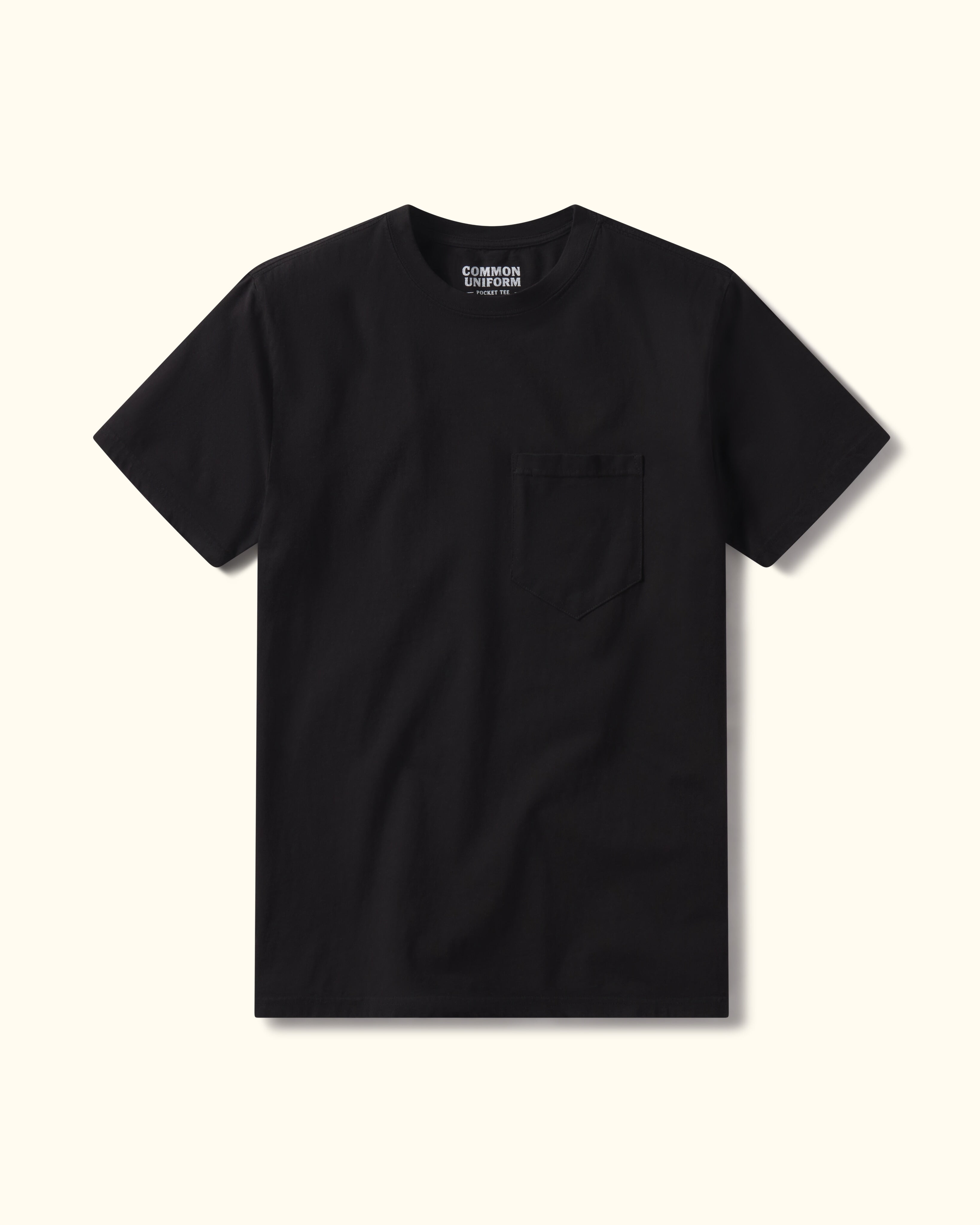 Black t-shirt with a pocket on a beige background
