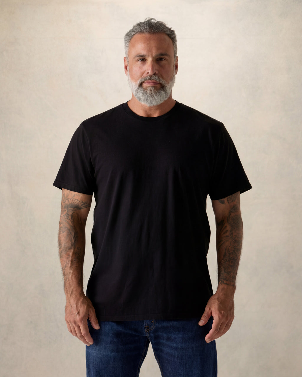 Man wearing a black t-shirt against a beige background. Model is 5'11", 210lbs wearing size XL